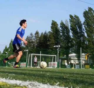 guy in blue jersey running on futsal pitch