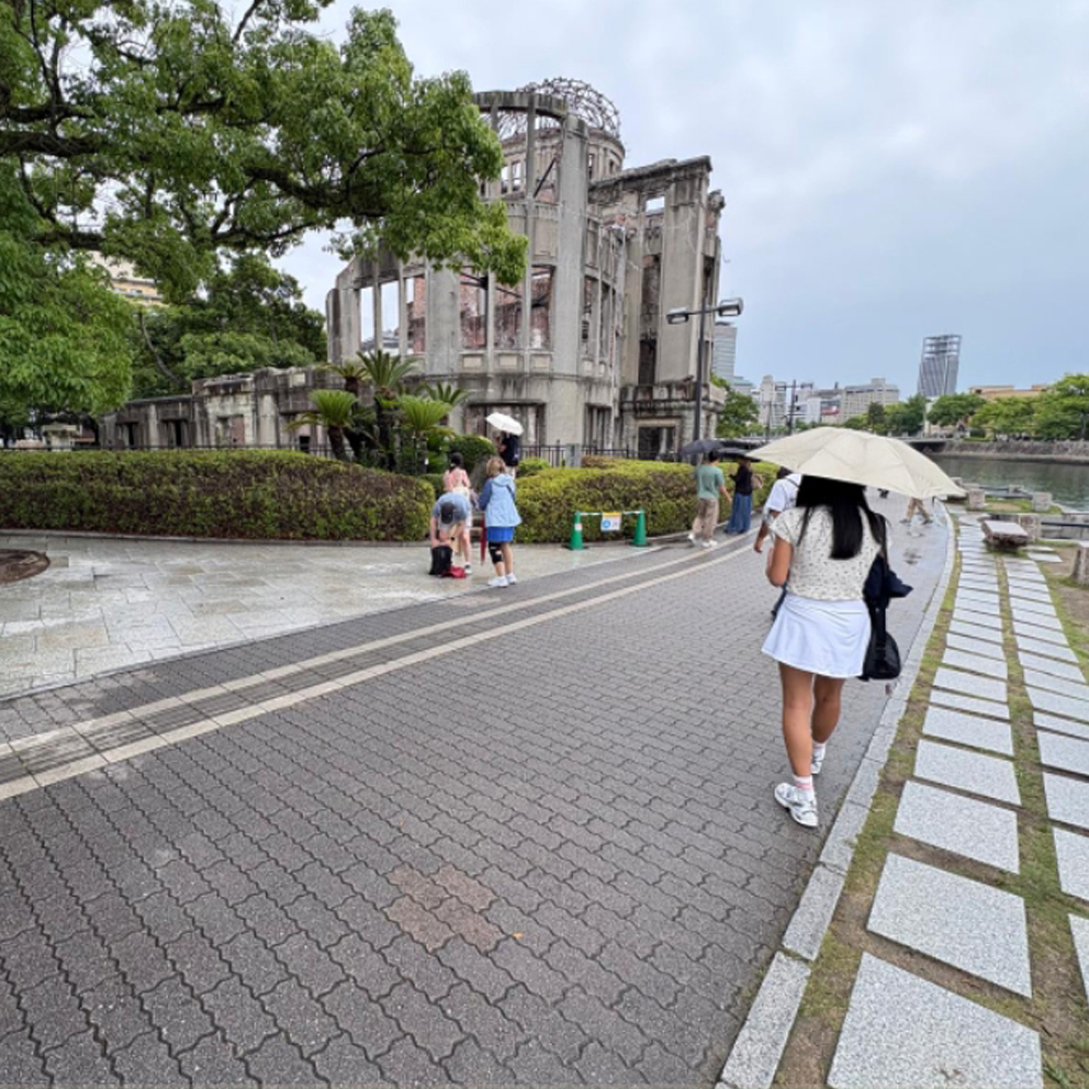 Asian girl with an umbrella crossing the street